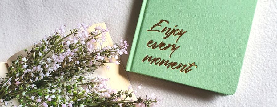 Benefits Of Gratitude Journaling Written Into A Green Notebook With Gold Writing On The Cover