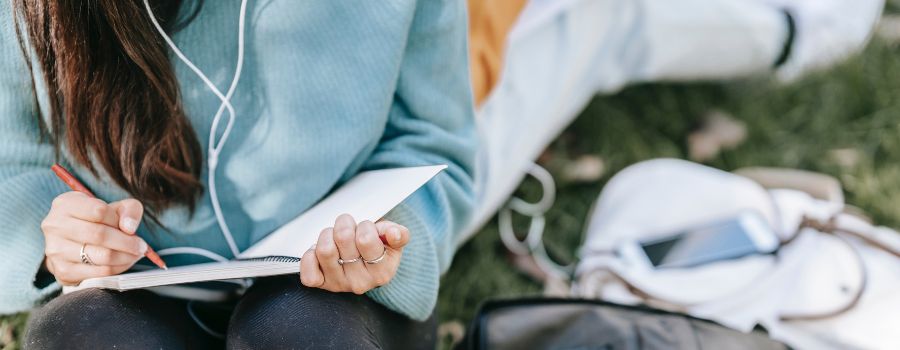 Best Journal Tips For Beginners Graphic Of Woman In Blue Sweater Journaling