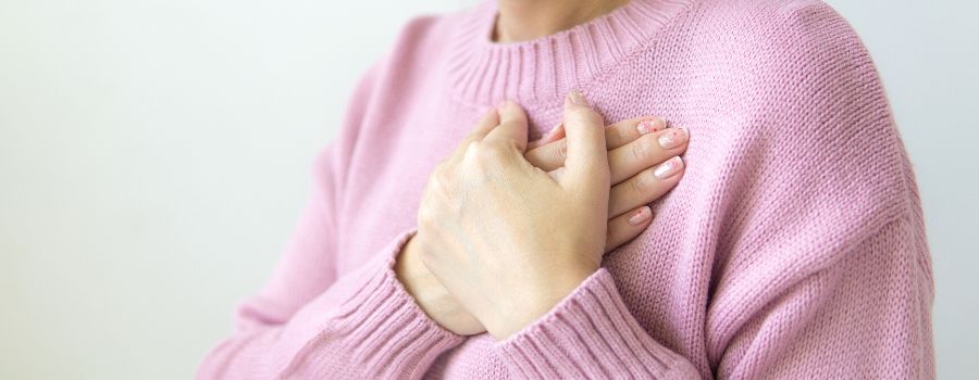 Self Love Affirmations Graphic Of A Women In Pink Jumper Holding Her Heart