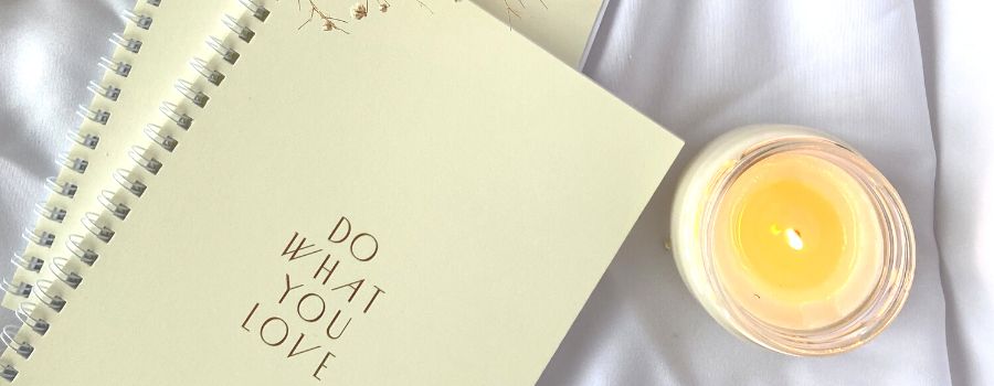 Two Yellow Journals On A White Cloth Filled With Journal Prompts For Goal Setting